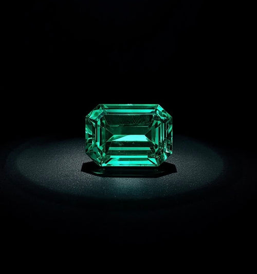Emerald-cut emerald under a single spotlight on a black background